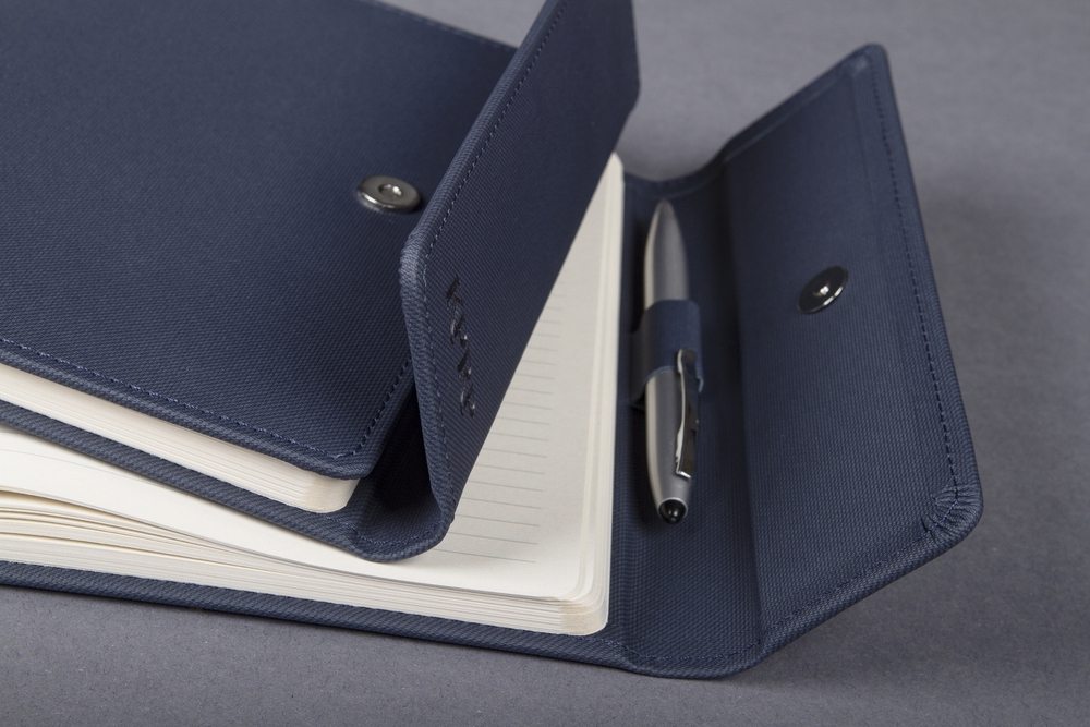 Navy A5 planner, flap open, pen loop and cream paper.